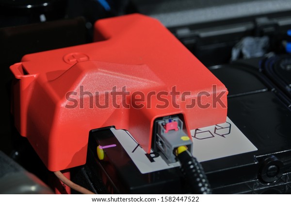 The plastic cover of the positive battery
cell tip with the red plus symbol, the battery is placed in the
engine compartment.