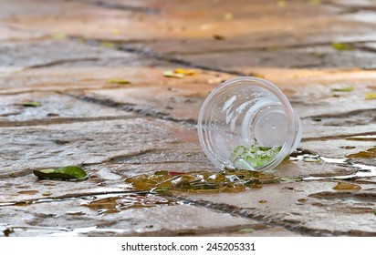 Plastic Cup Of Drinking Water And Ice Drop On The Floor.