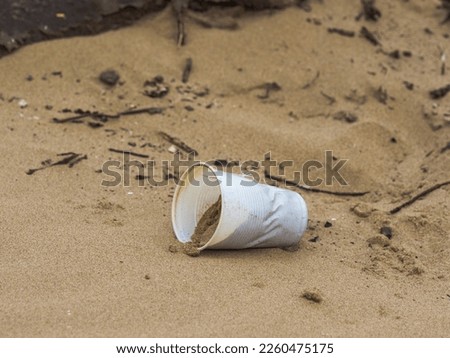 Plastic cup left on the beach discarded by uncaring people