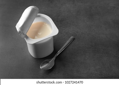 Plastic Cup With Yogurt On Dark Background