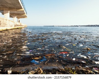 Plastic Debris On Blue Sea Surface. Polluted Beach. Garbage, Bottles And Other Plastic Debris In Ocean Water