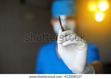 Plastic Doctor with a scalpel in his hand starts to operate. Professional surgeon in the operating room