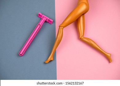 plastic doll legs with smooth velvet tanned skin and shaving machine on pink and grey background, hair removal and skin care concept