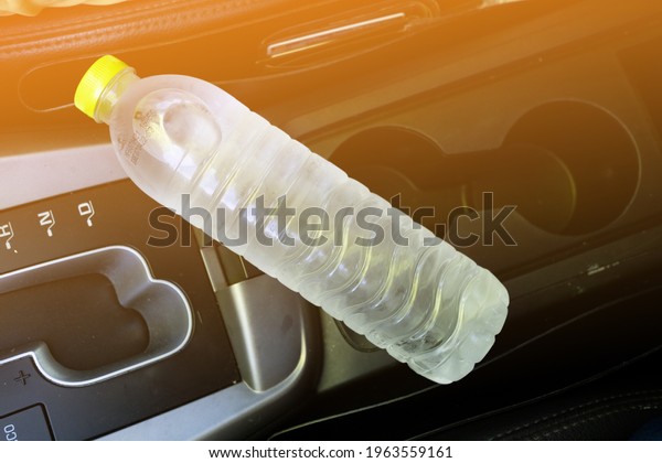 A plastic drinking\
water bottle in hot car with sunlight effect. Summer danger, The\
risk comes from the bottle of water being left in a car that\'s in\
direct sunlight.
