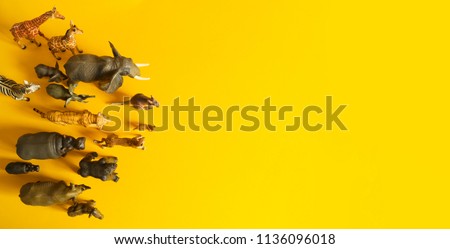 Plastic figurines of animals in hot countries. Protection of the animal. Children's toy. Yellow background.