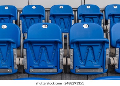 Plastic folding seats at the city stadium. Numbered seats, blue color, empty plastic seats, tribune. - Powered by Shutterstock