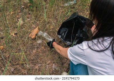 Plastic Garbage In Nature Clean Up Volunteer Hands Picks Up A Plastic Bottles In Forest. Environmental Conservation Volunteer Cleaning Up Forest