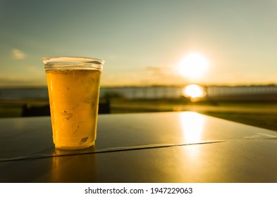 Plastic Glass Of Cold Beer On Table At Sunset On Guaíba Waterfront