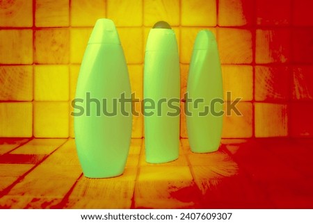 Plastic green glowing bottles for detergents orange wood background squares                               