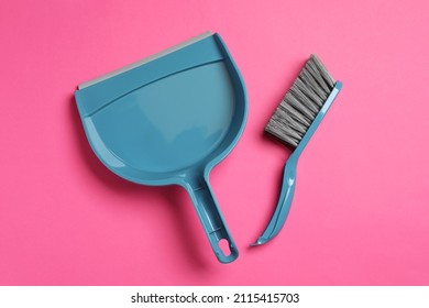 Plastic hand broom and scoop on pink background, flat lay