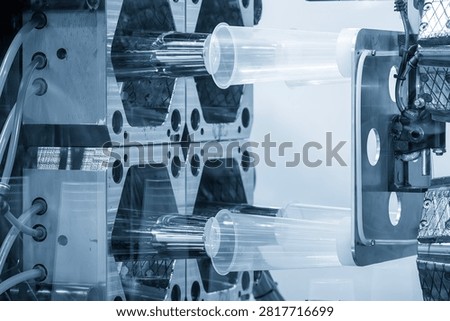 The plastic injection molding and high-volume packaging manufacturing process. They reveal the moment clear plastic cups are precisely molded and released from the mold on a high-capacity production line.