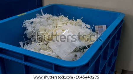 A plastic injection molding scrap in a container.