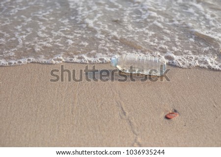 plastic jars are dumped at the beach. Is the toxic mass at the environment.