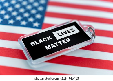 a plastic keychain with the symbol of the BLM movement. black lives matter on the background of the American flag