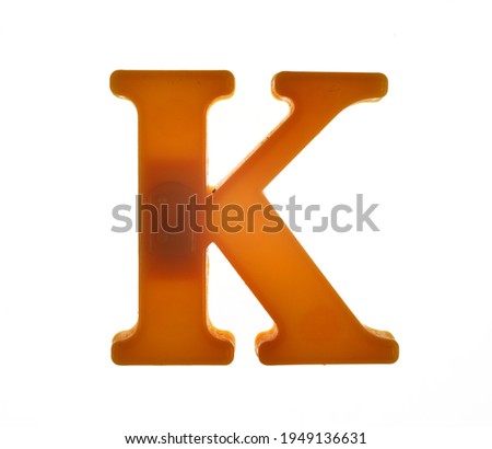 Plastic letter K on magnet isolated on white background, top view 