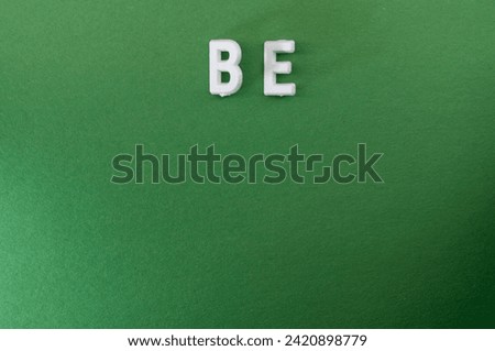 Plastic Letters Spelling the word be on a green background