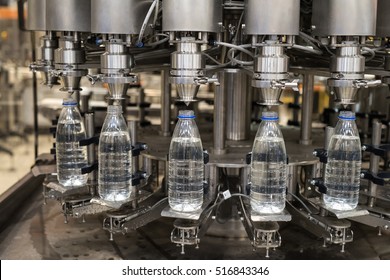 Plastic Liter Bottles On The Assembly Line Packaging Machine Pouring. Packing Shrink Food Equipment