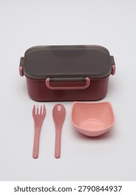 Plastic lunch box set with a small bowl, fork, and spoon on a white background