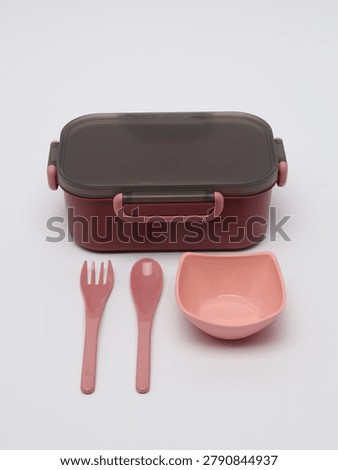 Plastic lunch box set with a small bowl, fork, and spoon on a white background