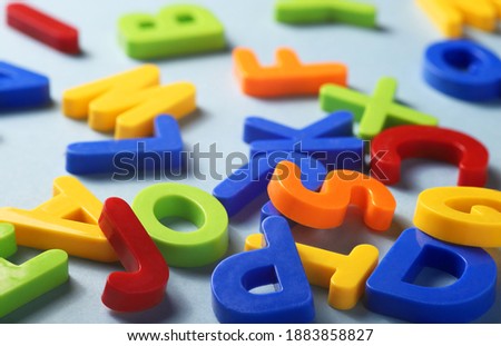 plastic multicolored letters of the latin alphabet on a blue background close-up