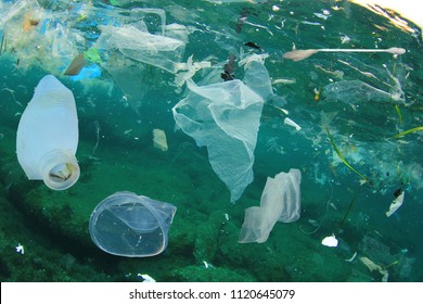 Plastic ocean pollution. Underwater bags, bottles, cups, straws and ear buds    
