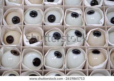  A lot of plastic ocular prostheses in a cardboard box. Glass eye prosthetic (Ocular prosthesis)                              