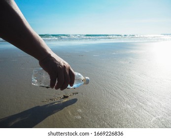 Plastik am Strand. Han abholen Plastikflasche putzen den Strand. Konzept der globalen Erwärmung