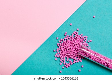 Plastic pallets . Plastic raw materials in granules for industry. Polymeric dye pink on a turquoise background. Plastic granules after processing of waste polyethylene and polypropylene.Polymer