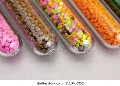 Plastic pellets .Polymeric dye in test tubes on gray background. Plastic granules after processing of waste polyethylene and polypropylene.Polymer. 