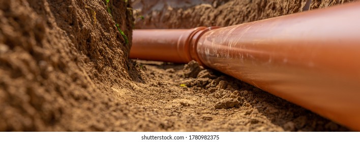 Plastic pipes in the ground during the construction of a building, bunner with copy space - Shutterstock ID 1780982375
