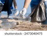 Plastic pollution and environmental problem concept. Close up of female volunteers hands with collecting plastic cup on the beach. Greening the planet. Recycle reduce and reuse concept.