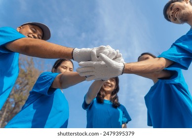 Plastic pollution and environmental problem concept. Happy asian diverse group of volunteers with garbage bags wearing blue t-shirt and cleaning plastic on the beach. Volunteers collecting trash. - Powered by Shutterstock