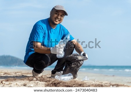 Plastic pollution and environmental problem concept. Close up male volunteer with garbage bags cleaning plastic on the beach. Volunteers collecting plastic bottle in a trash bag. Greening the planet.
