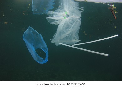 Plastic Pollution In Ocean Problem. Carrier Bags And Straws In Ocean