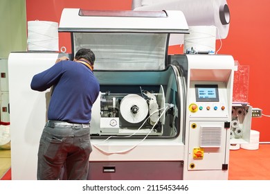 Plastic pp spool winding machine and worker - Powered by Shutterstock