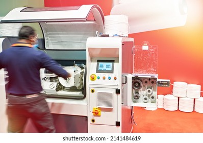 Plastic pp spool winding machine and worker - Powered by Shutterstock