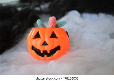 Plastic pumpkin buckets with candy on black and white smoke background - Powered by Shutterstock