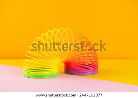 Plastic rainbow, 90s toy on a colorful background.