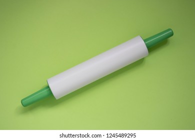 Plastic Rolling Pin On A Green Background