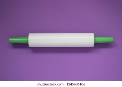 Plastic Rolling Pin On A Purple Background