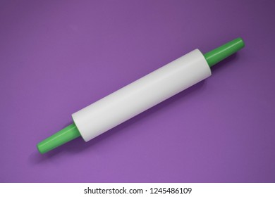 Plastic Rolling Pin On A Purple Background