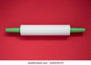 Plastic Rolling Pin On A Red Background