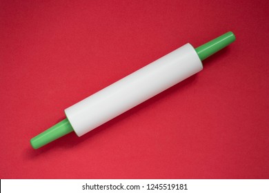 Plastic Rolling Pin On A Red Background