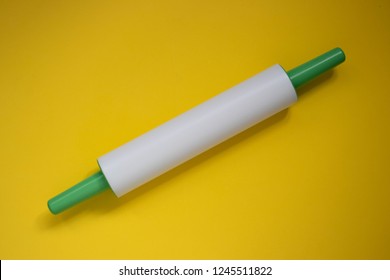 Plastic Rolling Pin On A Yellow Background