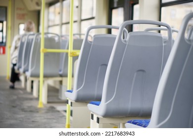 Plastic seat backs in an empty interior of a city tram, trolleybus or bus. Inside view. Selective focus. Small zone of sharpness. Daylight