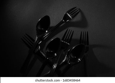 Plastic set fork and spoon on black background