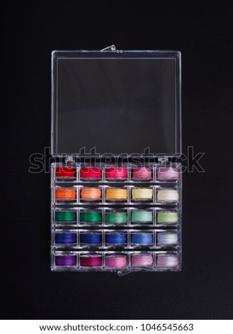Plastic sewing machine with colorful threads bobbins in storage box