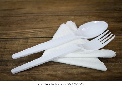 Plastic Spoon And Fork On Wood.
