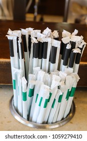 Plastic straws with paper wrappers in counter holder - the straws that many states and countries are outlawing but are still used many places