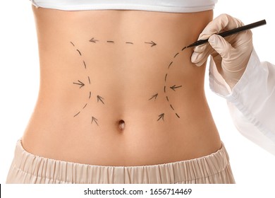 Plastic surgeon applying marking on female body against white background, closeup